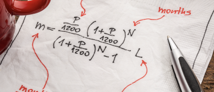 loan payment equation sketched on a white napkin with a cup of coffee